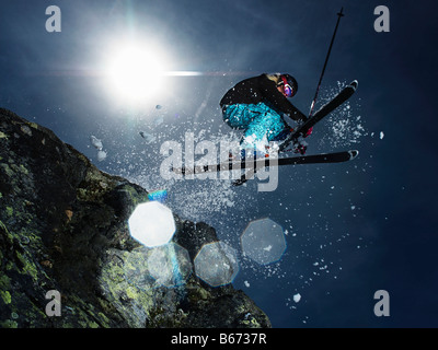 Skifahrerin über Felsen springen Stockfoto