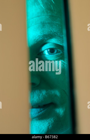 Gefängnis Officer Blick durch das Glas in einer Zellentür Stockfoto