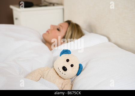 Frau im Bett mit Teddybär