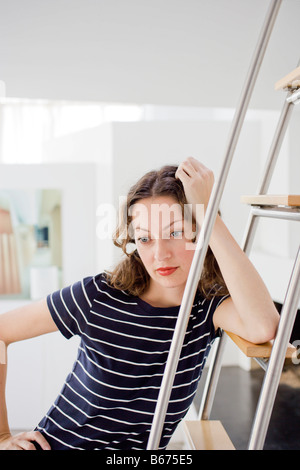 Geschäftsfrau an Leiter gelehnt Stockfoto