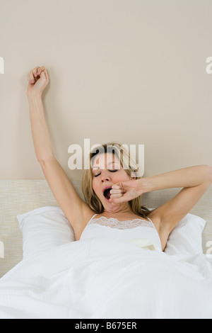 Frau im Bett zu gähnen Stockfoto