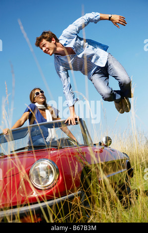 Mann springt aus einem Auto Frau innen Stockfoto