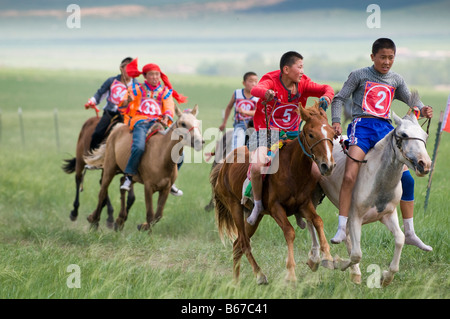 Ethnischen mongolischen kostümierten jungen jockeys Rennpferde im Sommer Naadam Festival Xiwuzhumuqinqi Innere Mongolei China Stockfoto