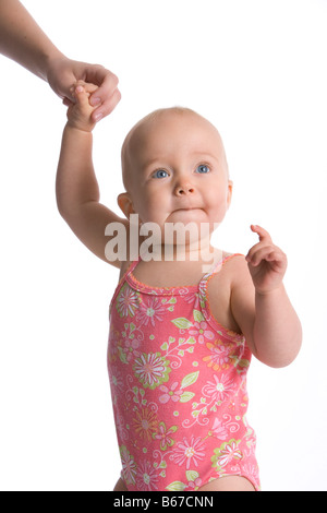 Babymädchen stehend mit Mütter hand Stockfoto
