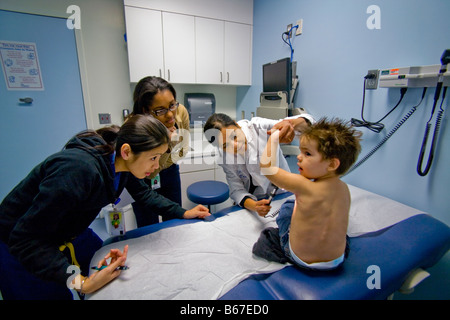 Ein weibliches Personal Arzt zeigt Bewohner Prüfung Technik am Childrens Hospital of Orange County in Orange, Kalifornien, USA Stockfoto