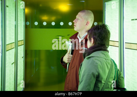 Pendler betrachten Zeitplan Display Pinnwand am Bahnhof Brüssel-Midi, Belgien. Stockfoto