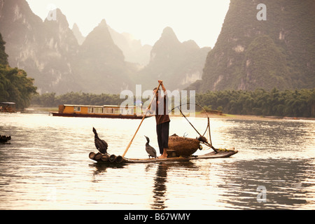 Fischer auf einem hölzernen Floß mit verschiedensten Hügel im Hintergrund, Guilin Hügeln, XingPing, Yangshuo, Provinz Guangxi, China Stockfoto