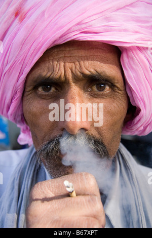 Porträt von einem indischen Mann mit Rauch kommt aus seiner Nase, trägt einen rosa Turban, Rauchen eine Bidi in Jaipur, Indien Stockfoto
