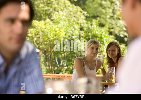 Flirten im Biergarten, zwei junge Frauen und zwei Männer flirten im Biergarten, Starnberger See, Bayern, Deutschland Stockfoto