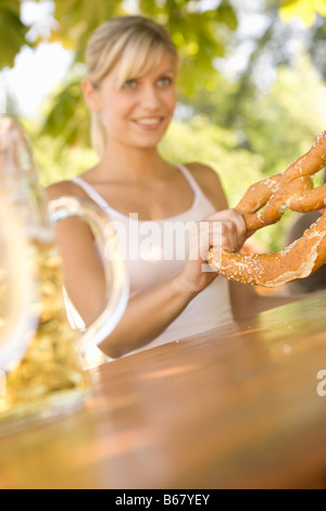 Junges Paar in einem Biergarten teilen eine Brezel, Starnberger See, Bayern, Deutschland Stockfoto