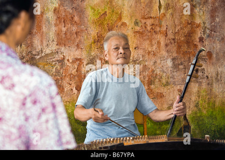 Senior Woman spielen Erhu, Fuli Dorf, Yangshuo, Provinz Guangxi, China Stockfoto