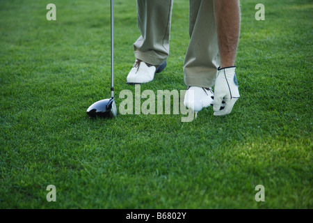 Golfer platzieren Ball am Abschlag Stockfoto