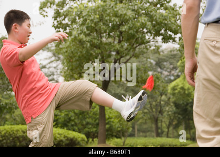 Junge mit seinem Vater stand vor ihm mit einem Federball spielen Stockfoto