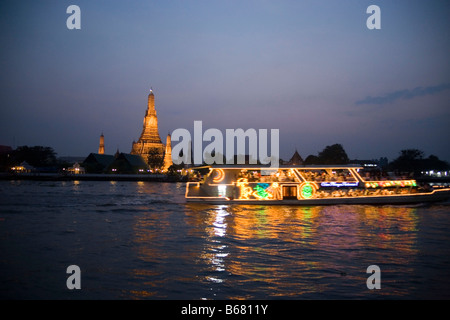 Blick über den Fluss Menam Chao Phraya mit einem Restaurantschiff nach Wat Arun, der Tempel der Morgenröte, Bangkok, Thailand Stockfoto