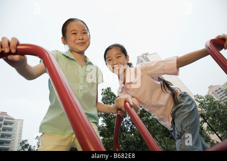 Niedrigen Winkel Ansicht eines Mädchens und ihre Schwester spielen auf einem Karussell Stockfoto