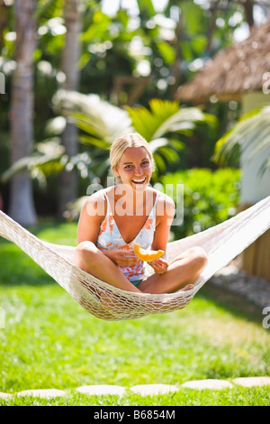 Frau sitzt in einer Hängematte Stockfoto