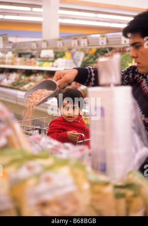 Hispanische Vater und kleinen Jungen wählen Sie Obst im Supermarkt. Stockfoto