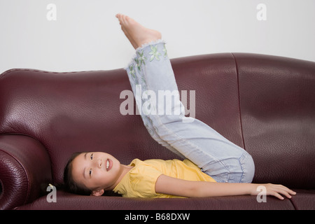 Seitenansicht eines Mädchens, das Spielen auf einer couch Stockfoto