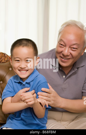 Porträt von einem reifen Mann und sein Enkel lächelnd Stockfoto