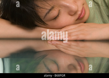 Weibliche Büroangestellte Nickerchen an einem Tisch Stockfoto