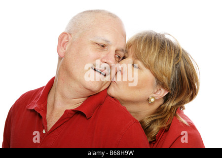Mittleren gealterten paar isoliert auf weiß Frau ist Mann auf die Wange küssen. Stockfoto