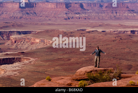 Eine männliche Figur stehen am Rand einer Klippe mit Blick auf den Colorado River Schlucht Sky Island Canyonlands National Park, Utah Stockfoto