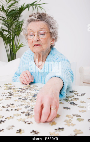 Ältere Frau tun Jigsaw puzzle Stockfoto