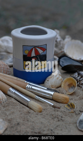 Pinsel und Muscheln am Strand Stockfoto