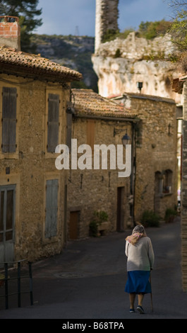 Alte Dame Walking down Street, Minerve, Languedoc-Roussillon, Frankreich Stockfoto