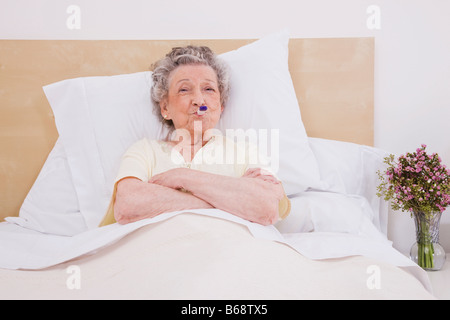 Ältere Frau mit Thermometer im Mund, Porträt Stockfoto