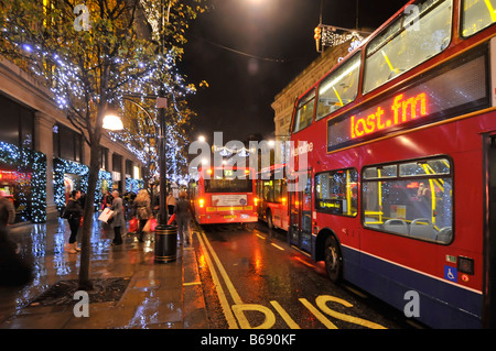 Oxford Street Shopper und Weihnachten Dekorationen London Bus beleuchteten Werbetafel im Regen draußen Selfridges Shop Stockfoto