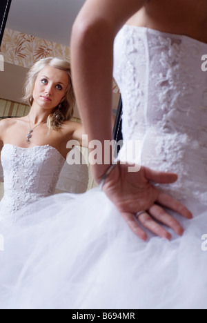 Braut im Hochzeitskleid selbst im Spiegel betrachten Stockfoto