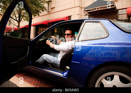 Ein Mann in einem Porsche 944 S2, Ankunft in der Stadt Stockfoto