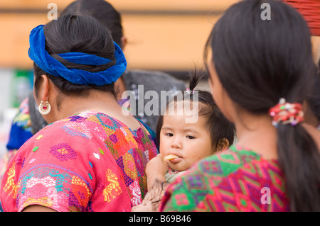 Einheimische Frau mit Kind in Schal in bunten traditionellen Kleid. Santa Maria de Jesus, Guatemala Stockfoto