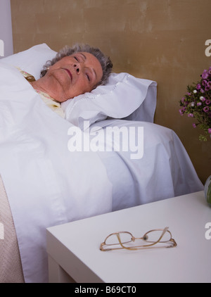 Ältere Frau schlafend im Bett Stockfoto