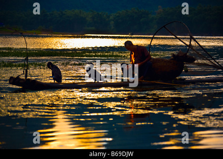 Silhouette eines älteren Mannes sitzen in einem hölzernen Floß, Li-Fluss, XingPing, Yangshuo, Provinz Guangxi, China Stockfoto