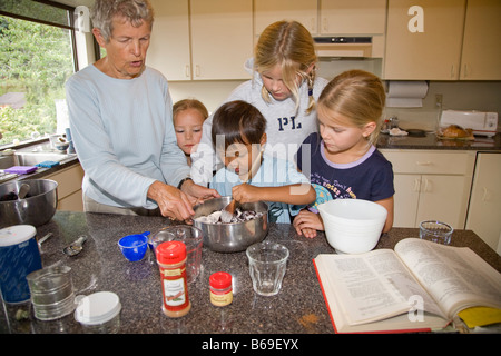 Frau unterrichtet, um ihre Enkel in der Küche kochen Stockfoto