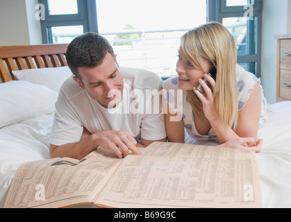 Paar überprüfen, Aktien und Anteile im Bett Stockfoto