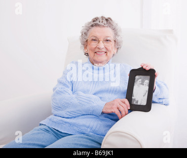 Porträt des Lächelns senior Frau zeigt Schwarz-weiß Fotografie Stockfoto