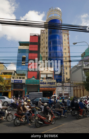 Stromleitungen über einer chaotischen Verkehr verstopfte Straße vor einem modernen Gebäude in Ho Chi Minh City, Vietnam Stockfoto