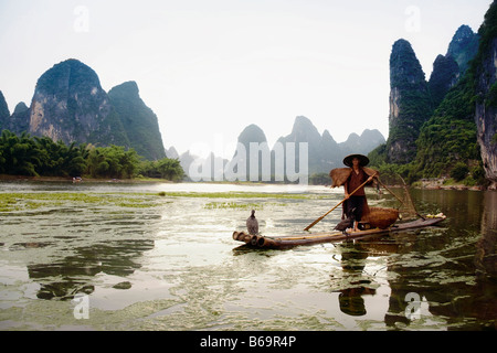 Fischer auf einem Bambusfloß mit verschiedensten Hügel im Hintergrund, Guilin Hügeln, XingPing, Yangshuo, Provinz Guangxi, China Stockfoto