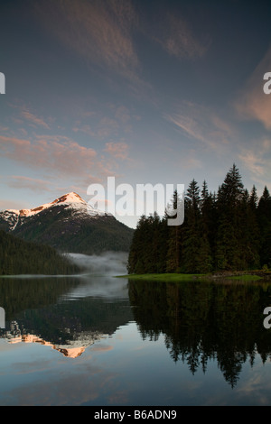 USA Alaska Misty Fjords National Monument Einstellung Sonne leuchten schneebedeckte Berggipfel entlang Rudyerd Bay am Sommerabend Stockfoto