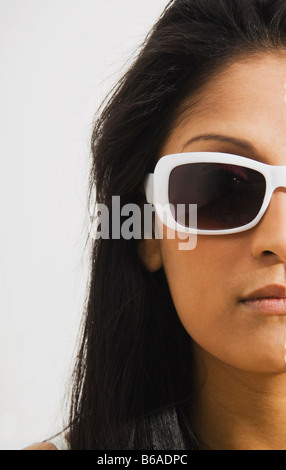 Studio-Porträt der jungen Frau mit Sonnenbrille Stockfoto