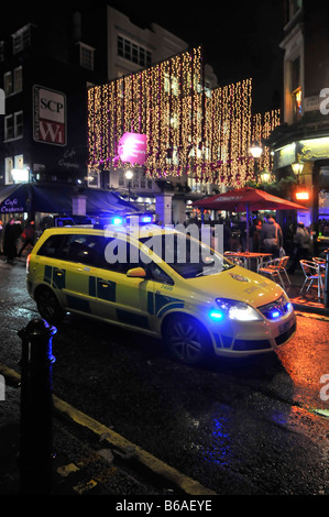 London West End Nacht Ambulanz Auto Fahrer auf Notfall 999 Anruf stecken in der Hauptverkehrszeit Verkehrsstau blaue Lichter und beleuchtete Weihnachtsdekorationen uk Stockfoto