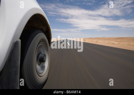 Afrika Namibia Keetmanshoop Low Winkel Blick auf Safari-Truck fahren auf asphaltierten Highway durch die Namib-Wüste Stockfoto