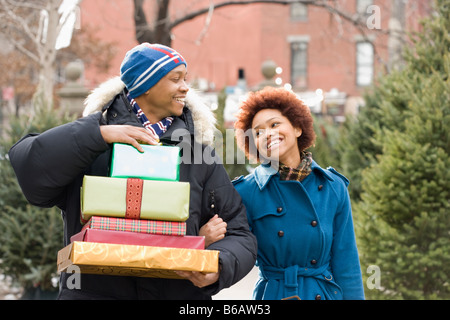 Afrikanischer Mann trägt Stapel von Weihnachten Geschenke für Freundin Stockfoto