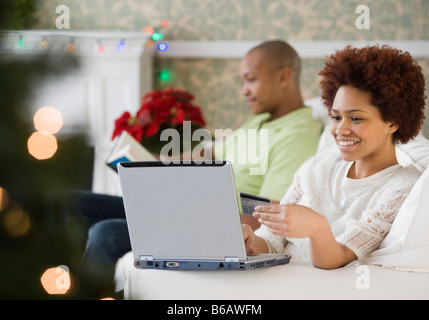 Gemischte Rassen Frau kaufen Weihnachten präsentiert online mit Kreditkarte Stockfoto