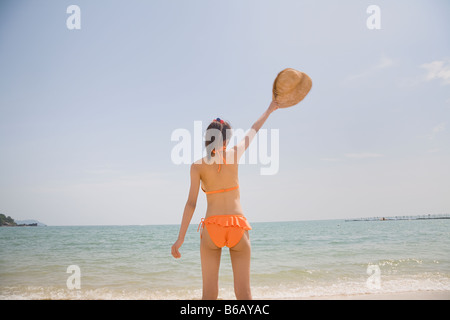 Junge Frau im Bikini am Strand zu stehen Stockfoto