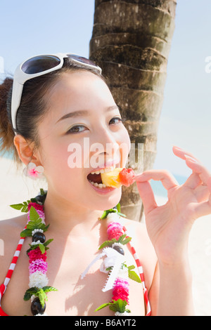 Junge Frau im Bikini, die Früchte zu essen Stockfoto