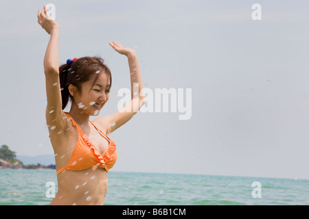 Junge Frau im Bikini, Spritzwasser Stockfoto